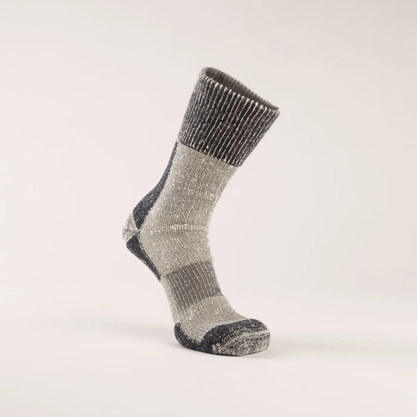 A single wool sock with gray and dark gray stripes and reinforced toes and heel, standing upright against a plain, light background.
