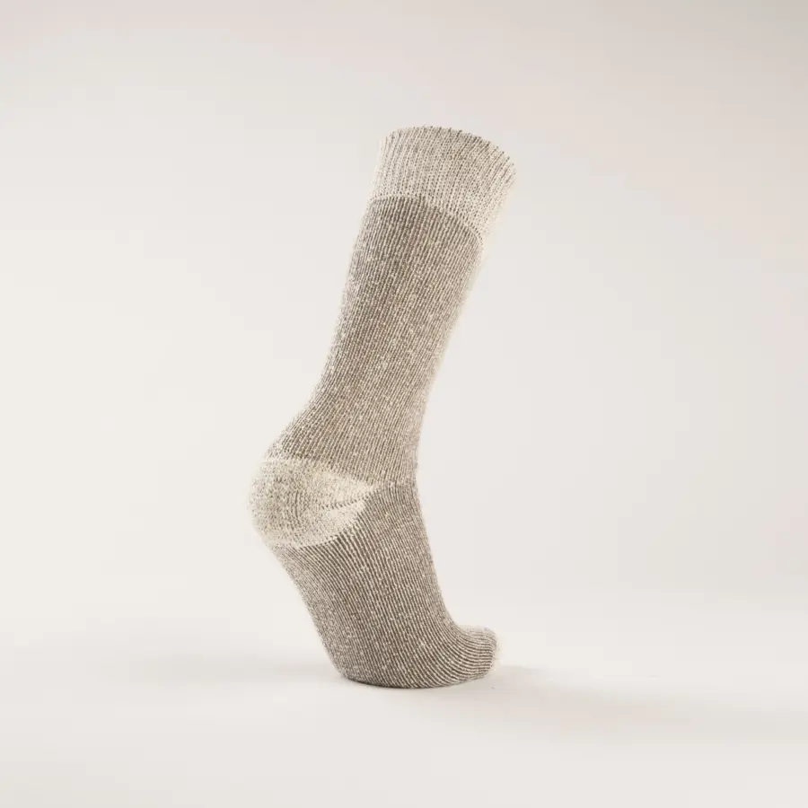 A single gray wool sock standing upright on a plain, light-colored background, showing the side view with the heel and toe visible.