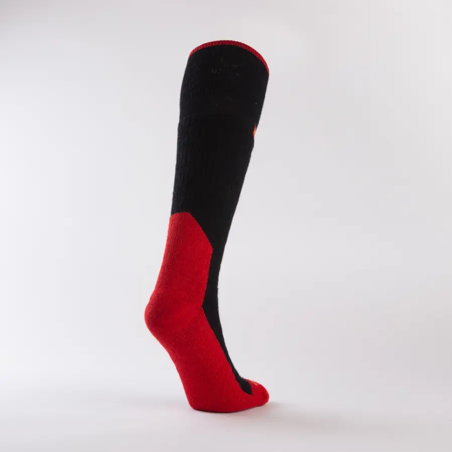 A single knee-high sock with a black upper section and a red heel, toe, and sole, standing upright against a plain white background.
