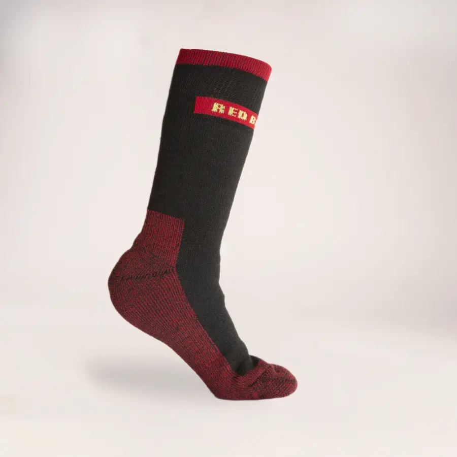 A single black and red sock displayed upright on a white background, with the word RED visible in yellow letters on the upper cuff.