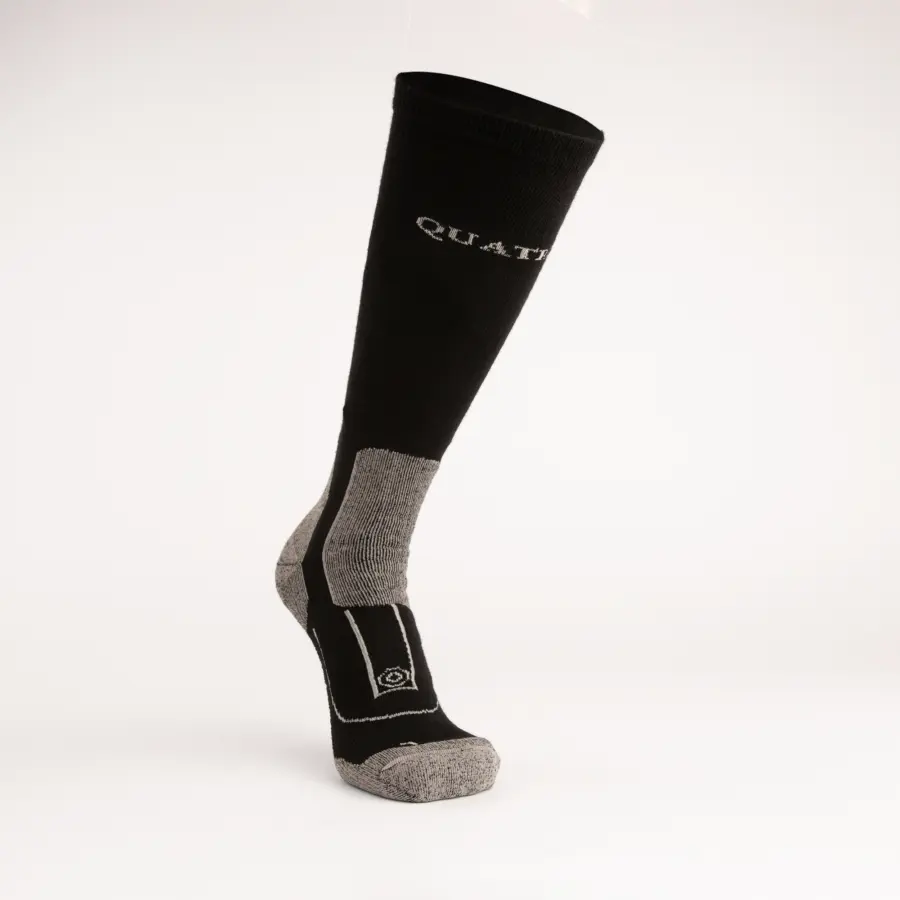 A single knee-high black sock with gray heel, toe, and sole accents, displayed on a white background. The sock features the word QUAT partially visible near the top.