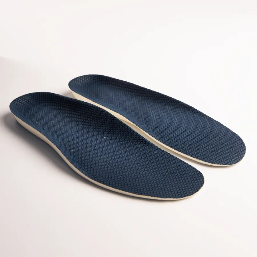 A pair of dark blue textured shoe insoles with white edges, placed side by side on a light surface.