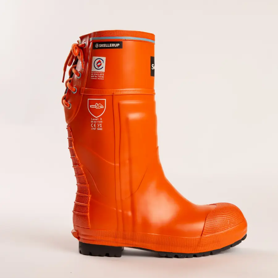 A single bright orange rubber work boot with black tread, side laces, and visible safety labels, standing upright on a white background.