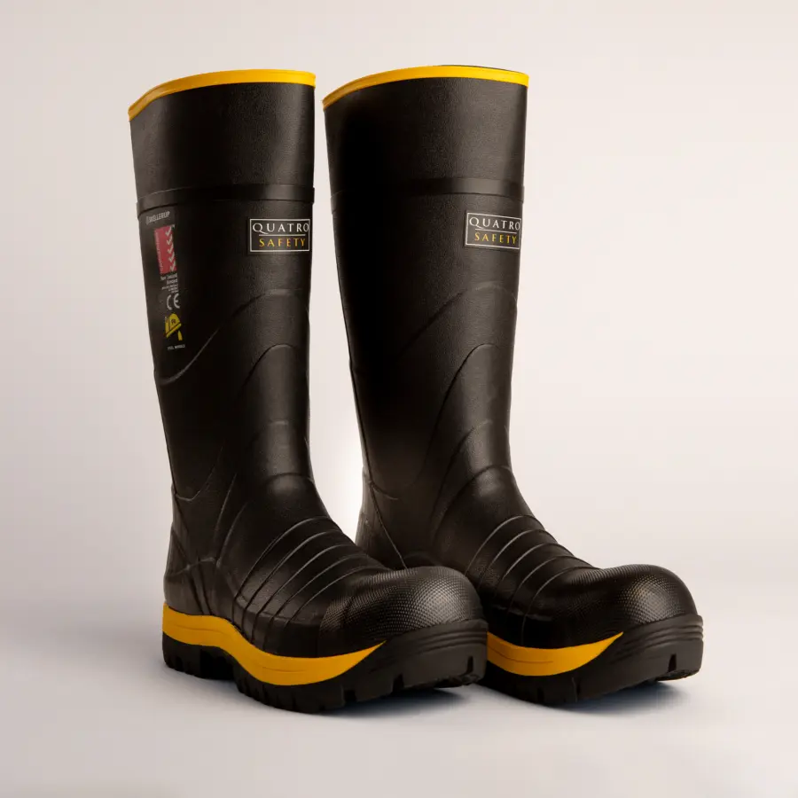 A pair of black safety work boots with yellow soles and accents, standing side by side on a white surface. The boots are labeled Quatro Safety and have a rugged, durable design.