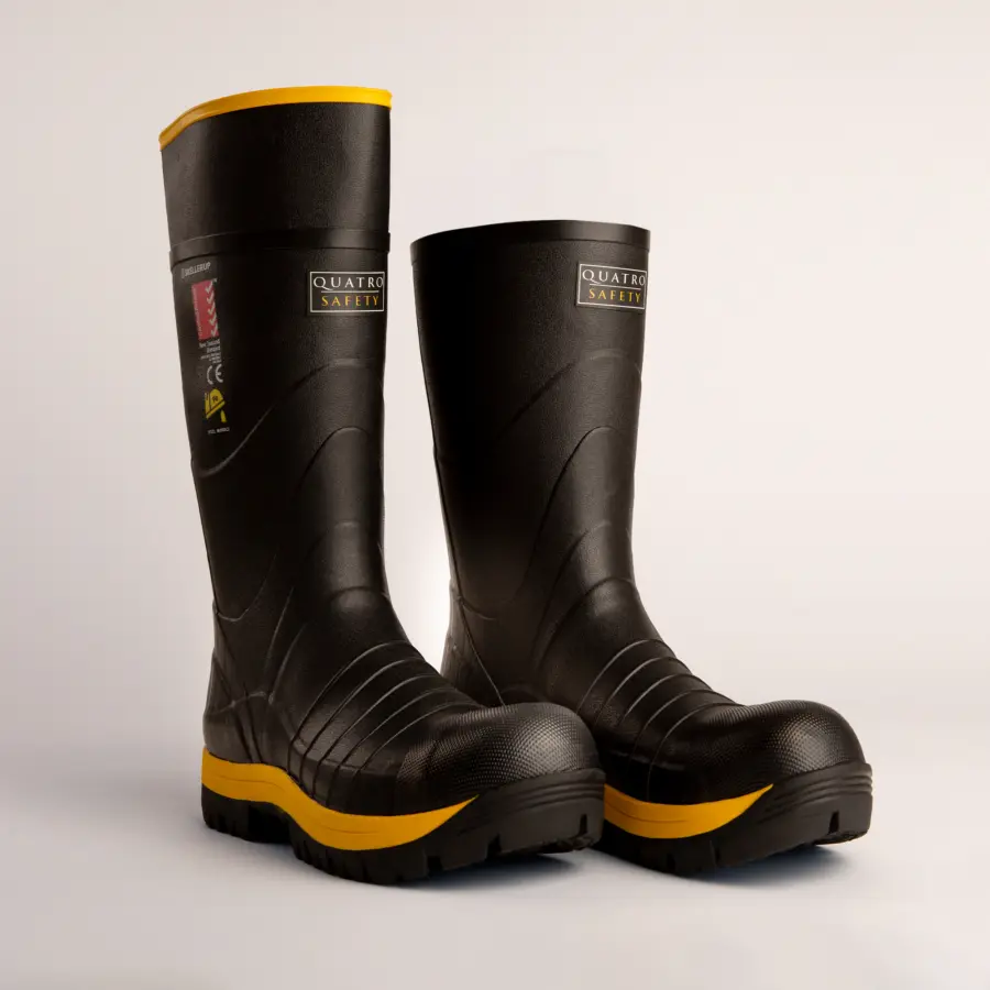 A pair of black safety boots with yellow soles and trim, featuring a textured surface and labeled Quatro Safety, displayed on a plain white background.