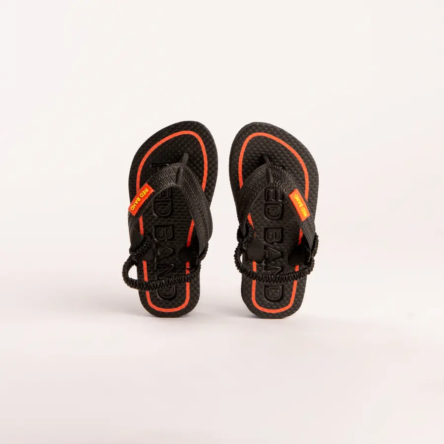 A pair of black sandals with red accents and yellow tags on the straps are displayed against a plain white background.