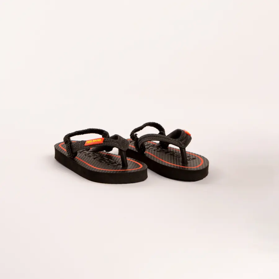 A pair of black flip-flop sandals with textured soles and orange accents, placed on a plain white background.