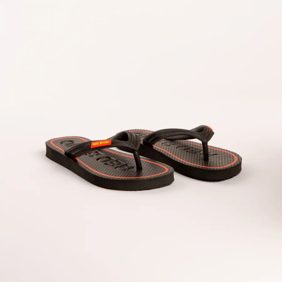A pair of black flip-flops with textured soles and red accents, including a small red label on the straps, placed on a plain white background.