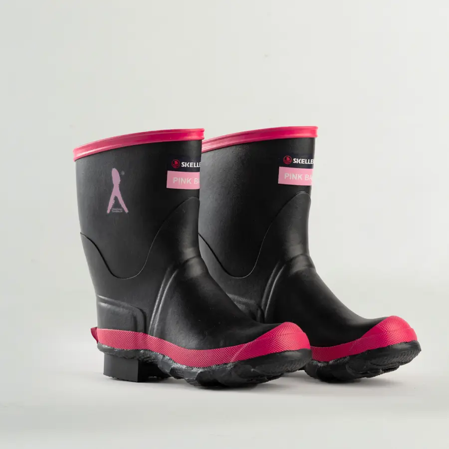 A pair of black rubber boots with pink soles and trim, featuring a “Pink Ban” label and a silhouette ribbon graphic on the side, set against a plain white background.