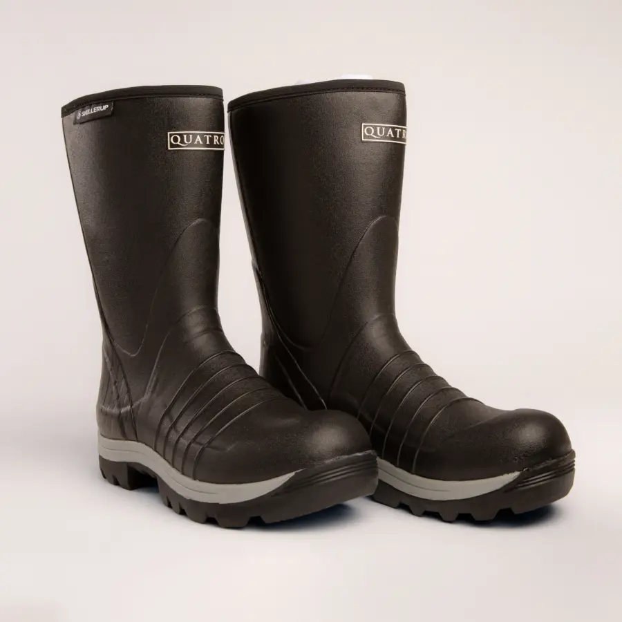 A pair of black rubber Quatro work boots with textured soles and a subtle gray trim, positioned side by side on a plain light background.