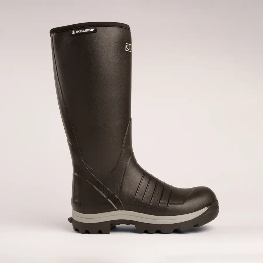 A single black rubber work boot with a textured sole and a slightly raised heel, shown in profile view against a plain, light-colored background.