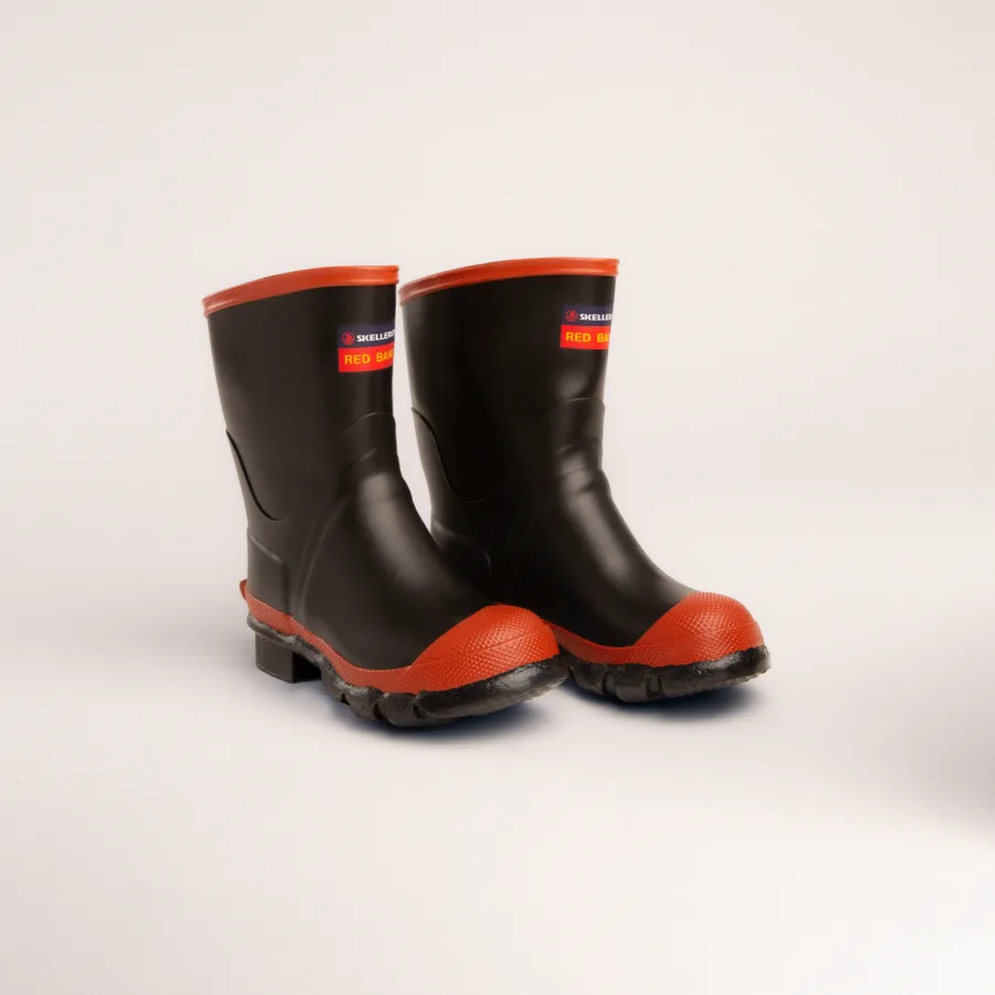 A pair of black rubber work boots with red soles and trim, positioned side by side on a plain white background.