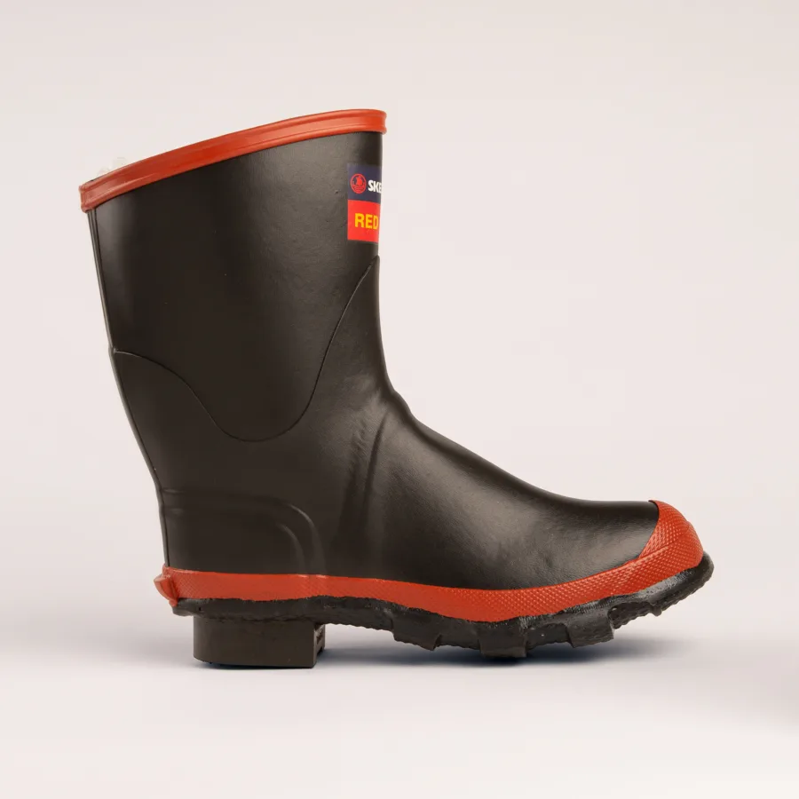 A single black rubber boot with a red sole and trim, featuring a rugged tread and a block attached to the heel, displayed against a plain white background.
